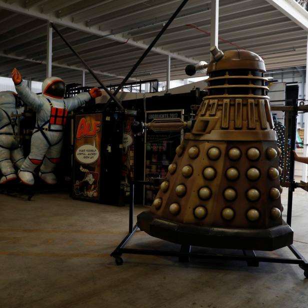 A worker pushes a model of a Dalek past other figures used in the illuminations at The Lightworks in Blackpool, Britain