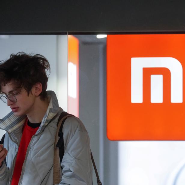 FILE PHOTO: A man uses his smartphone next to the Xiaomi brand's store in central Kiev