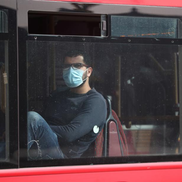 Ein Mann mit Schutzmaske in einem Bus in London