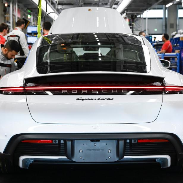 Ein weißer Porsche Taycan Turbo in einer Produktionshalle.