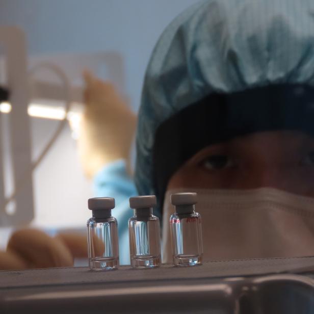 Ein Wissenschaftler überprüft die Qualitätskontrolle von Impfstofffläschchen auf korrektes Volumen in der Clinical Biomanufacturing Facility (CBF) in Oxford.