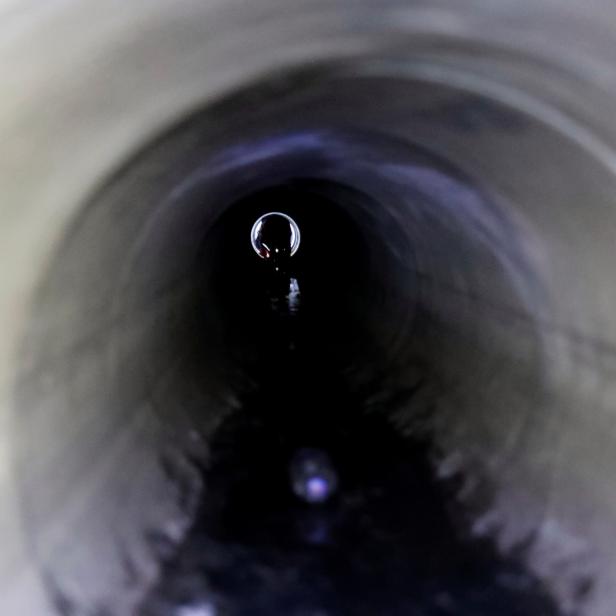 A protester tries to escape through a sewage tunnel inside the Hong Kong Polytechnic University campus, in Hong Kong