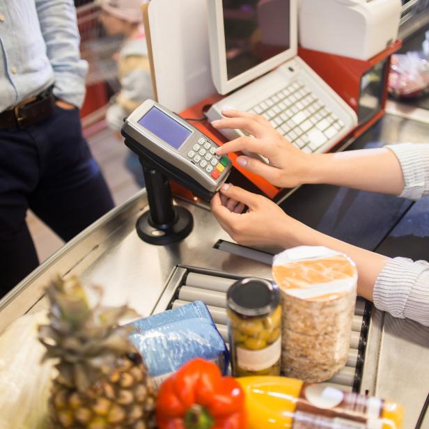 Cashier Using Payment Terminal in Supermarket