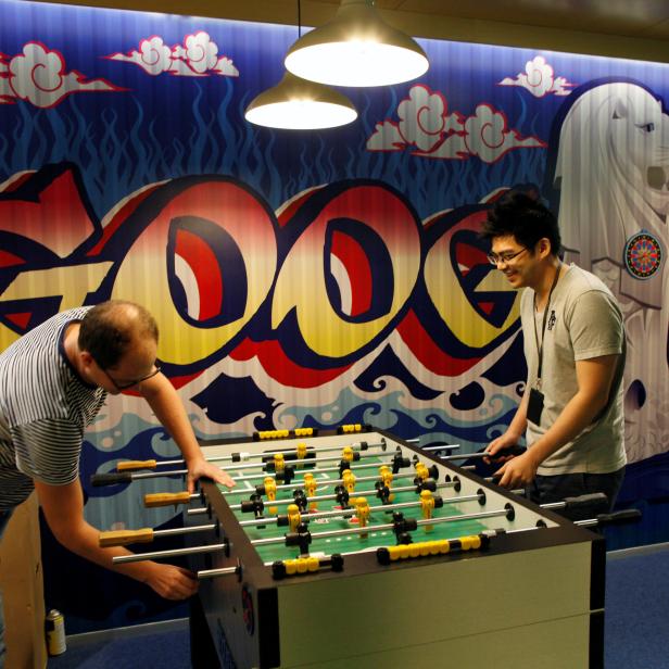 FILE PHOTO: Google's communications manager Moroney plays table soccer with a Google employee at a recreational area of their Singapore office