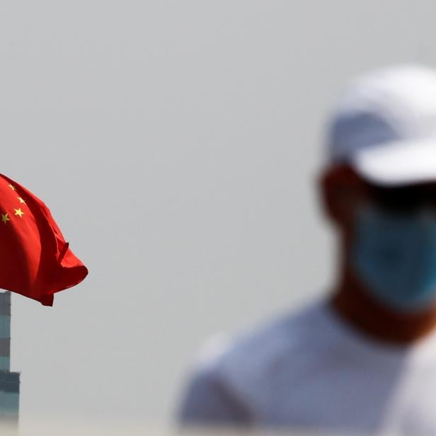 A man walks near the Chinese national flag in Beijing