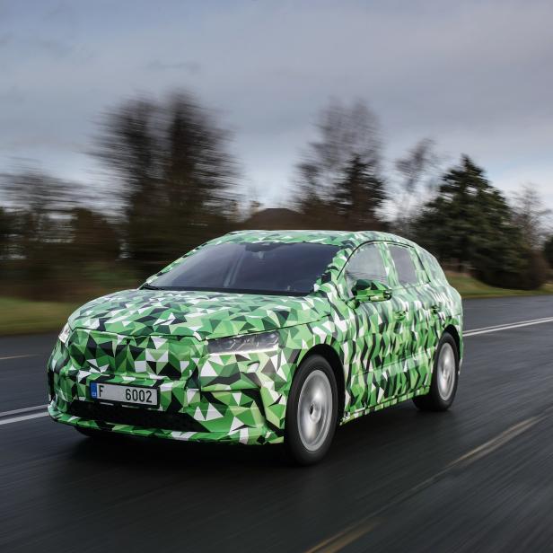 Ein mit grünem Tarnmuster beklebter Skoda fährt auf einer Landstraße.