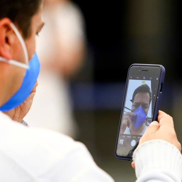 A man in a face mask takes a selfie at Ministro Pistarini International Airport in Buenos Aires
