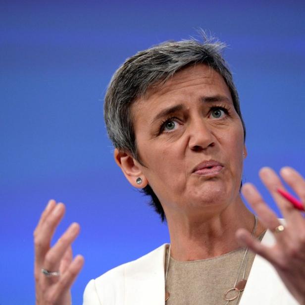 Margrethe Vestager gestikuliert vor einem blauen Hintergrund.