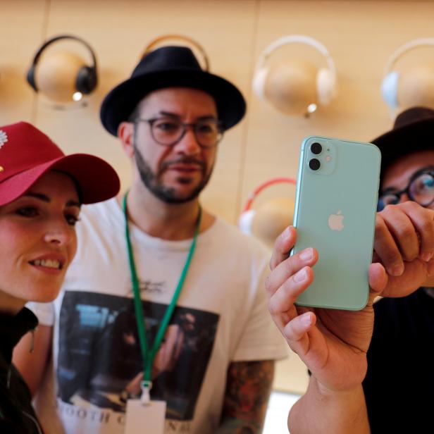 FILE PHOTO: People look at an app on the new iPhone inside the new Apple Store in Mexico City