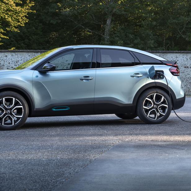 Ein hellblauer Citroën ë-C4 wird an einer Ladestation aufgeladen.
