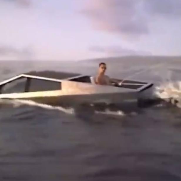 Ein Mann fährt mit einem Cybertruck-ähnlichen Boot auf dem Wasser.