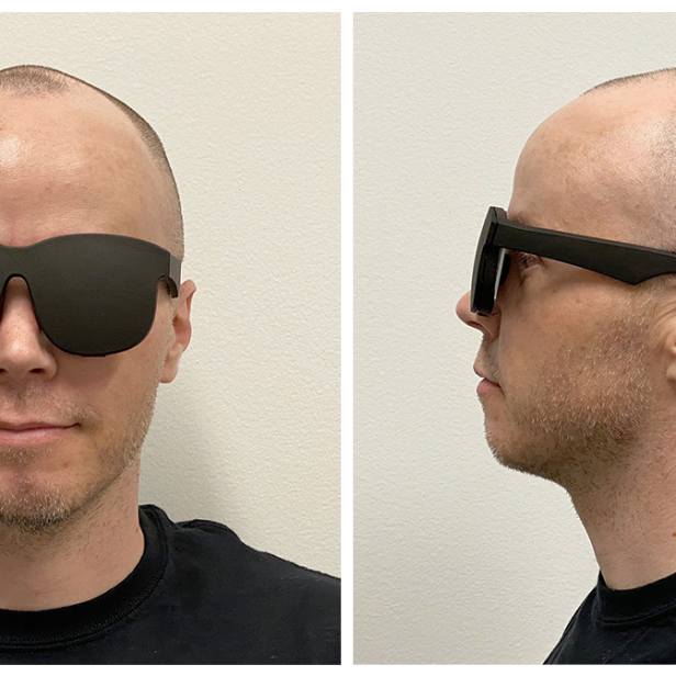 Ein Mann mit Glatze trägt eine übergroße, schwarze Sonnenbrille.