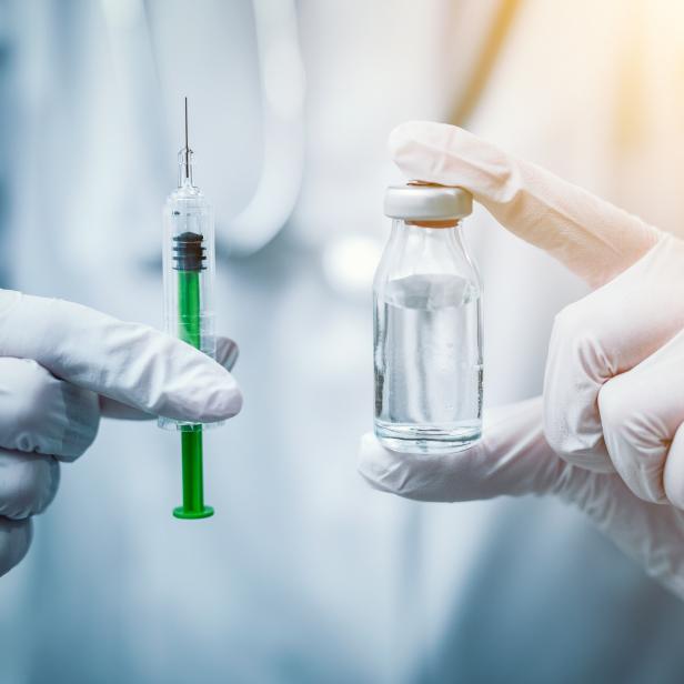 Syringe, medical injection in hand. Vaccination equipment.