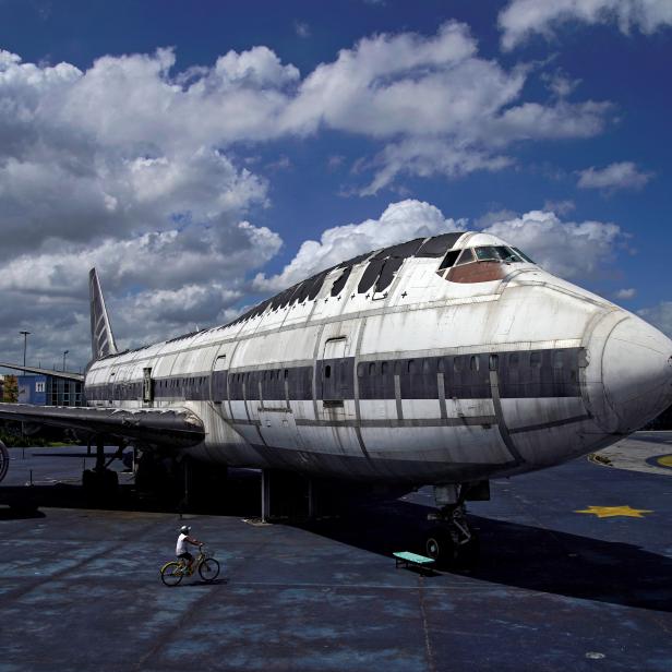 FILE PHOTO: A boy rides a bicycle next to retired Boeing 747 airplane on display at Shanghai Expo area, in Shanghai