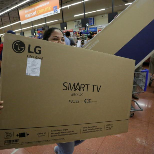 A shopper carries a Smart TV during the kick-off of the 'El Buen Fin' (The Good Weekend) holiday shopping season, at a Walmart store in Monterrey