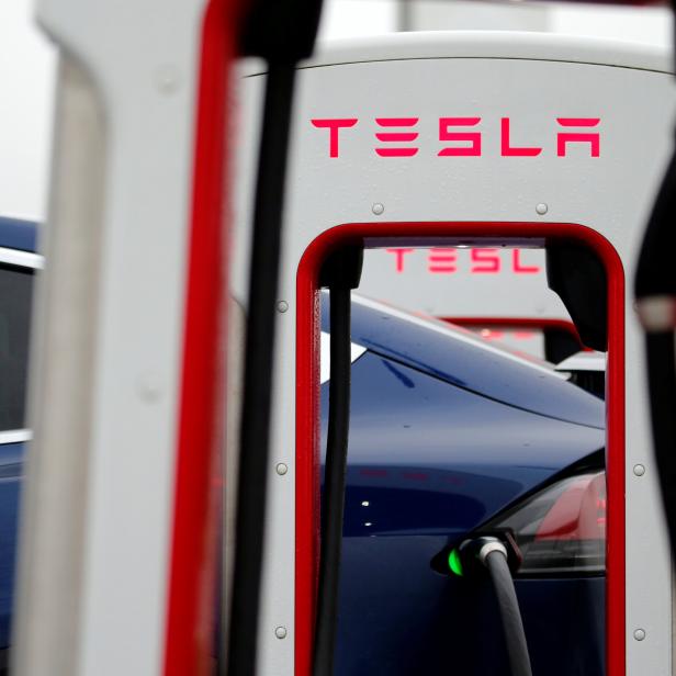 A driver recharges the battery of his Tesla car at a Tesla Super Charging station in a petrol station on the highway in Sailly-Flibeaucourt