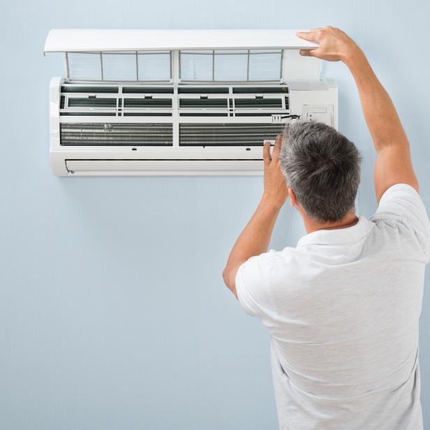 Man Cleaning Air Conditioning System