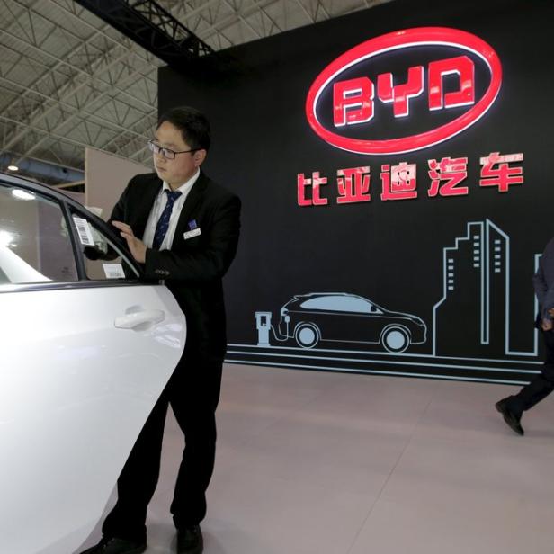 Ein Mann betrachtet ein Auto der Marke BYD auf einer Automesse.