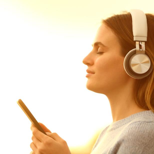 Girl listening to music with headphones and phone