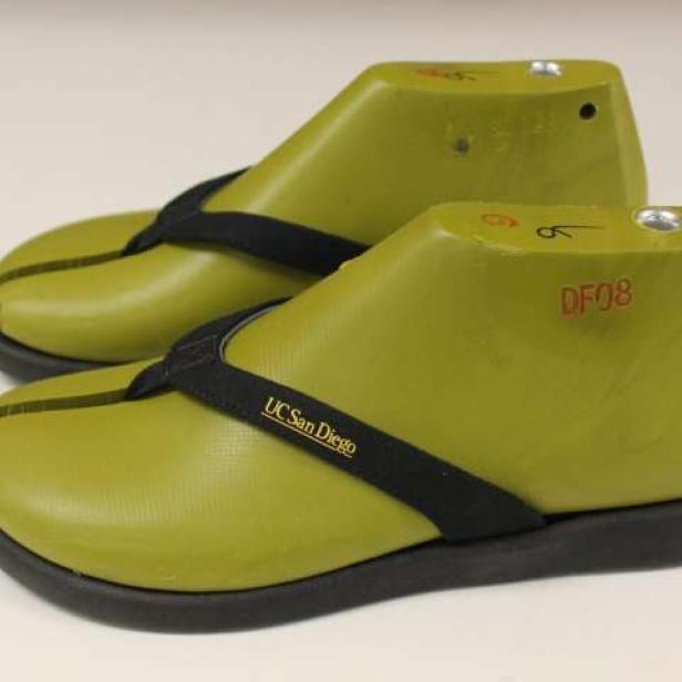 Ein Paar olivgrüne Sandalen mit dem Aufdruck „UC San Diego“.
