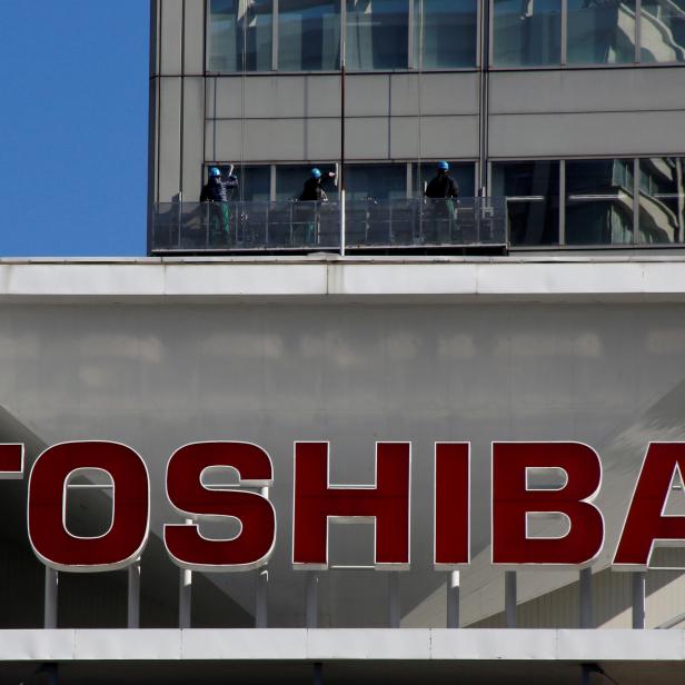 FILE PHOTO: Logo of Toshiba Corp is seen as Window cleaners work on the company's headquarters in Tokyo