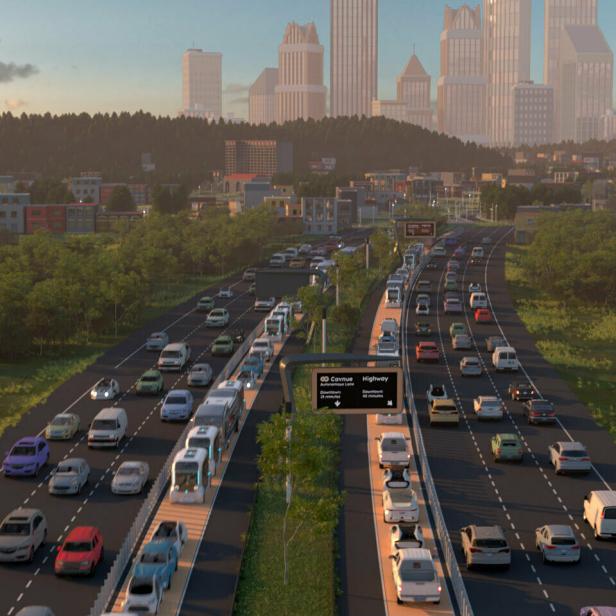 Eine belebte Autobahn führt auf eine Stadt zu.