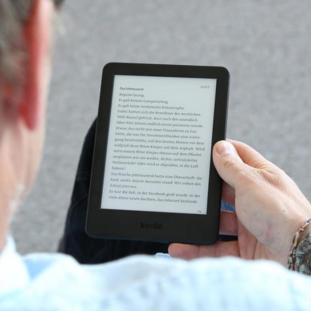 Ein Mann liest auf einem Kindle E-Reader.