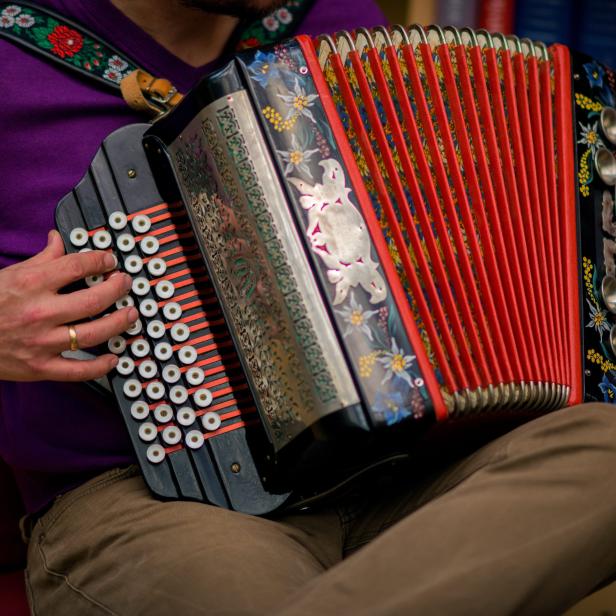 Ein Mann spielt auf einer steirischen Harmonika in Wien.