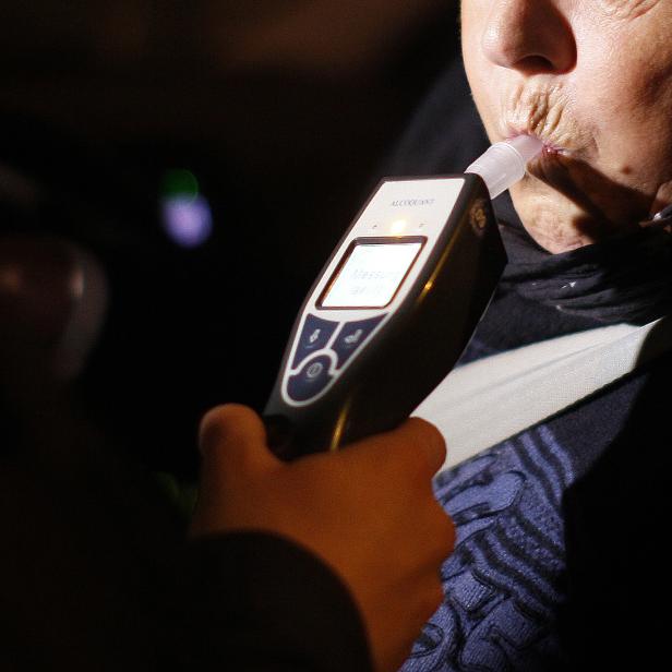 Polizeikontrolle: Eine Person führt einen Alkoholtest durch.