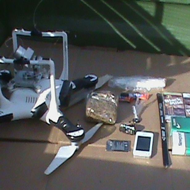 A drone carrying cellphones, drugs, hacksaw blades and other material that dangled in a bundle from a fishing line