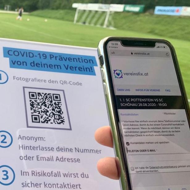 Ein Schild mit Informationen zur COVID-19-Prävention und ein Smartphone mit der Webseite vereinstix.at.