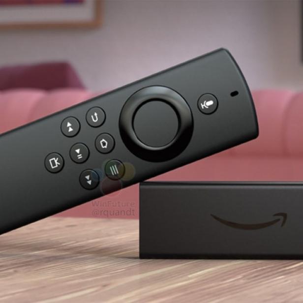 Ein Amazon Fire TV Stick und die zugehörige Fernbedienung liegen auf einem Tisch.