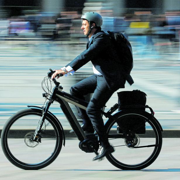 FILE PHOTO: A man rides an electric bicycle, also known as an e-bike, in downtown Milan