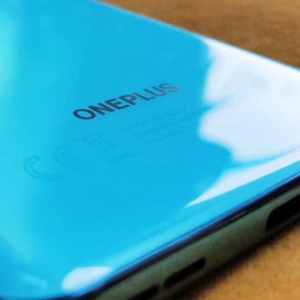 Nahaufnahme der Rückseite eines hellblauen OnePlus-Smartphones.