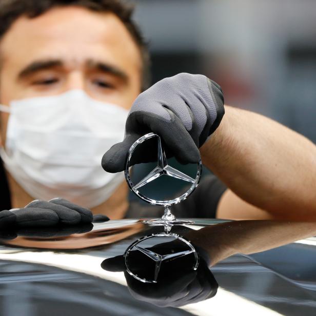 Ein Arbeiter montiert in Sindelfingen während der Corona-Pandemie einen Mercedes-Benz-Stern.