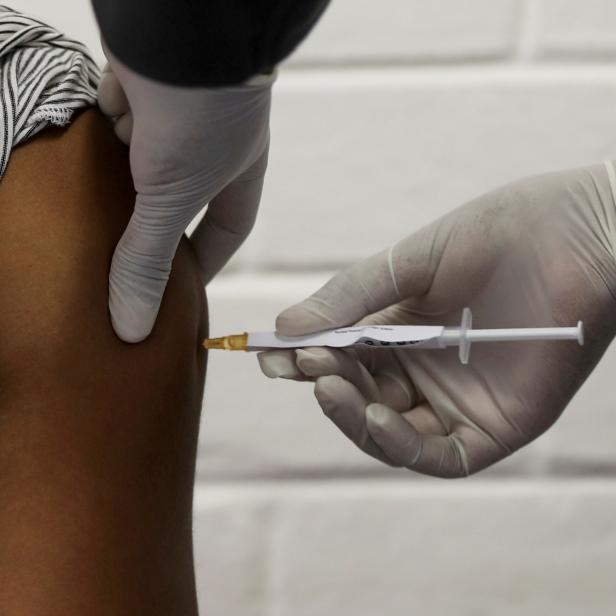 FILE PHOTO: A volunteer receives an injection from a medical worker during the country's first human clinical trial for a potential vaccine against the novel coronavirus, in Soweto