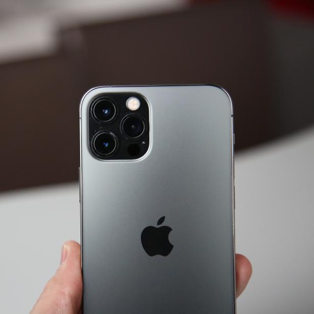 Nahaufnahme der Rückseite eines grauen iPhones mit drei Kameras.