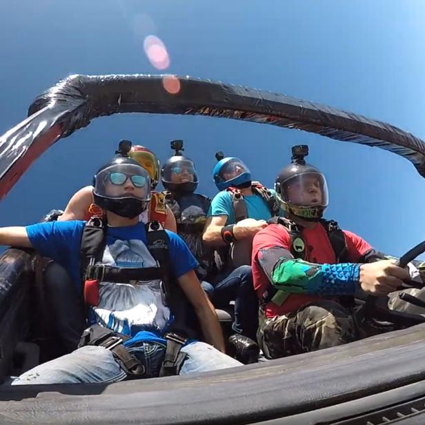 Ein Skydiving-Team lässt sich in einem Auto sitzend vom Himmel fallen