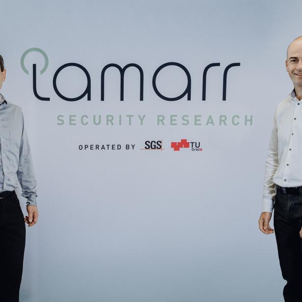 Zwei Männer stehen vor dem Lamarr Security Research Logo.