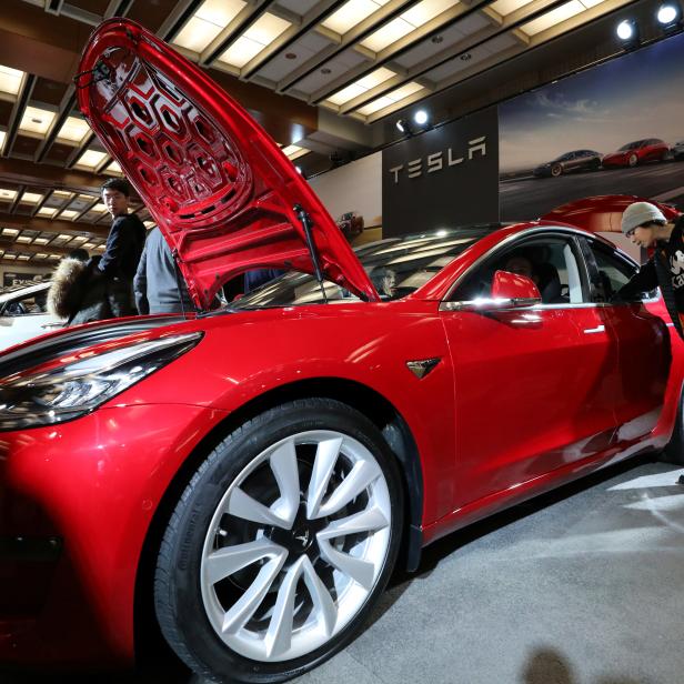 A visitor views the Tesla Model 3 electric vehicle at the Canadian International Auto Show in Toronto