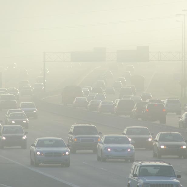 Cars at Rush Hour Driving Through Thick Smog