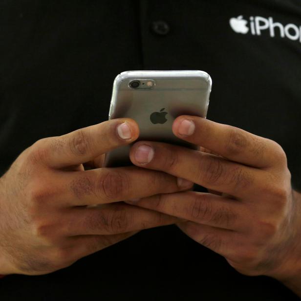 FILE PHOTO: A salesman uses his iPhone at a mobile phone store in New Delhi