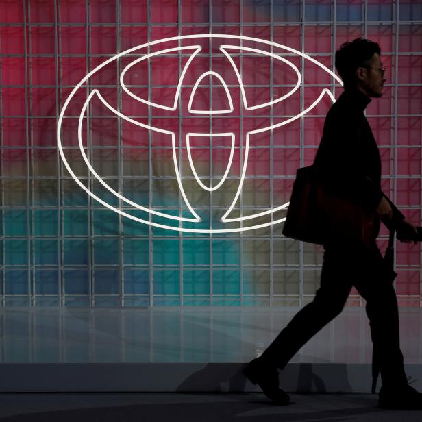 FILE PHOTO: A man walks past a Toyota logo at the Tokyo Motor Show