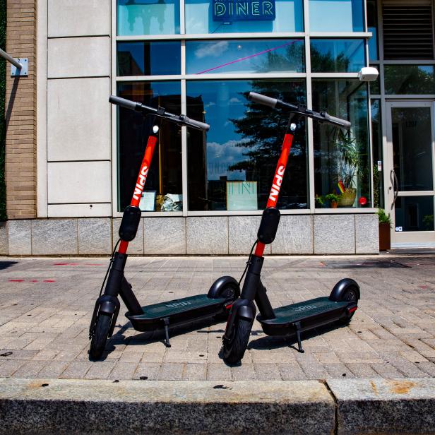 Zwei E-Scooter der Marke Spin stehen vor einem Diner.