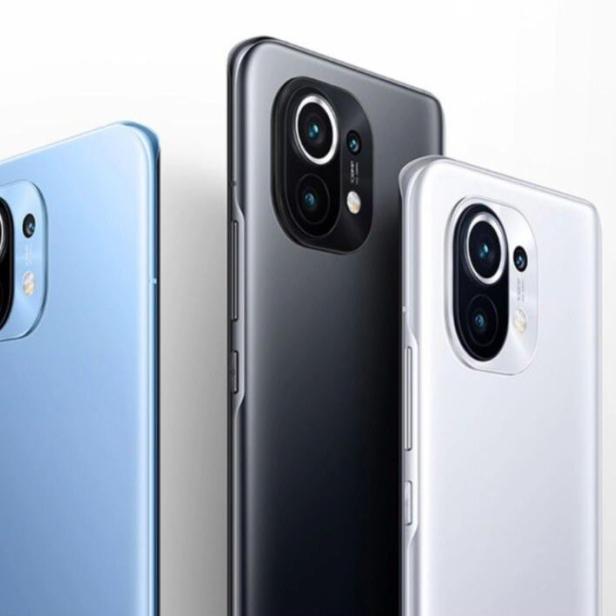 Drei Xiaomi Smartphones in den Farben Blau, Grau und Weiß stehen nebeneinander.