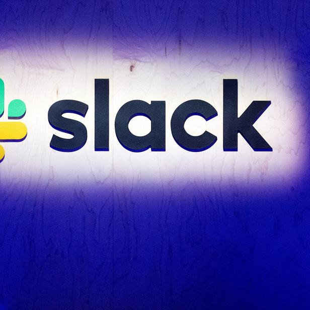 Das Slack-Logo vor einer blau beleuchteten Wand.