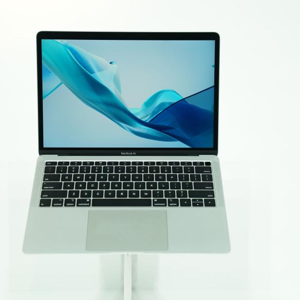 Ein MacBook Air steht auf einem weißen Tisch.