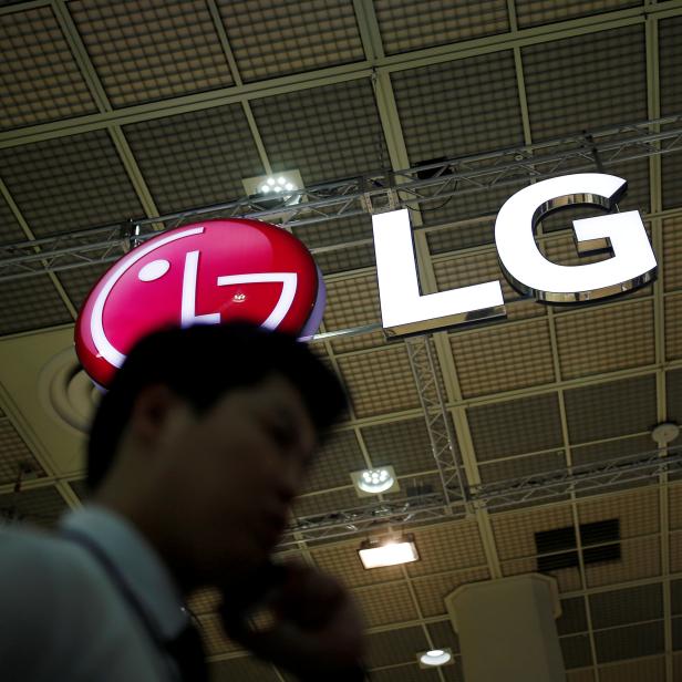 FILE PHOTO: A man talking on his phone walks past the logo of LG Electronics during Korea Electronics Show 2016 in Seoul