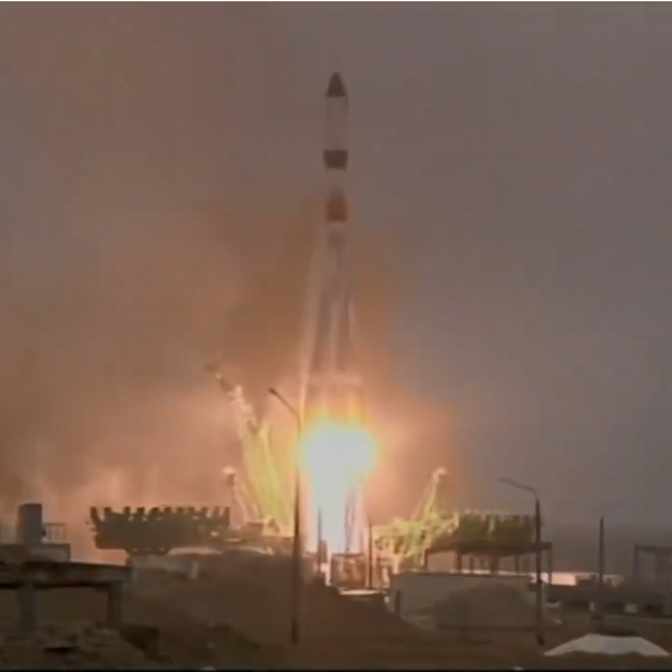 Eine Rakete startet mit hellem Feuer und Rauch von einer Startrampe.