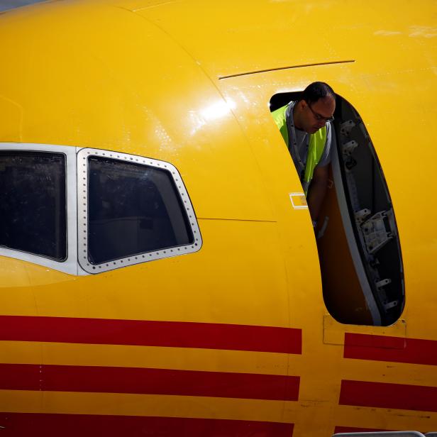 A technician looks out of the door of a DHL Boeing 757 aircraft before a charity fundraising event in which teams compete by pulling the aircraft for twenty metres at the Safi Aviation Park in Safi